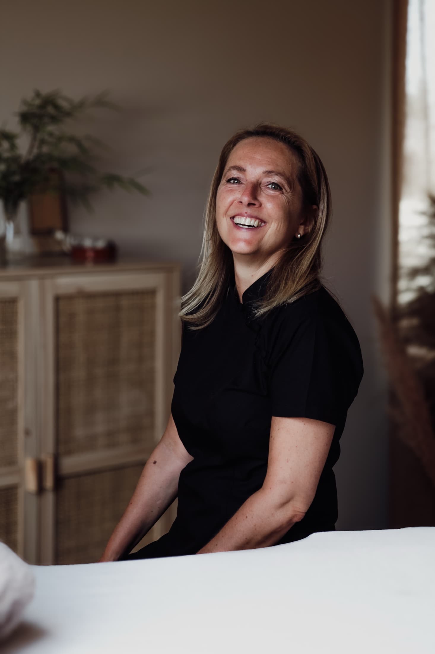 Sophie De Dycker, oprichtster van CupHealing, lachend in haar praktijk